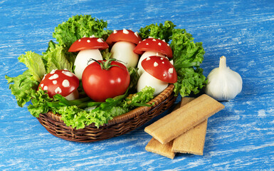 ripe tomatoes with mushroom eggs in a wicker basket with lettuce on a wooden blue background