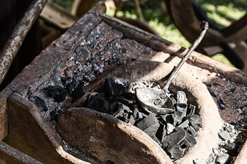 black coals stacked in a forge forging preparation for forging metal