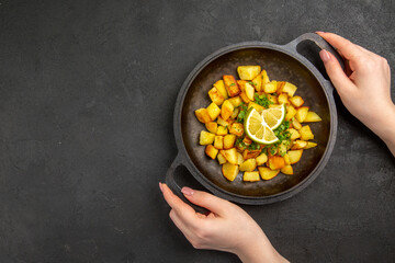 top view tasty fried potatoes inside pan with lemon slices on dark desk photo food cuisine meal color