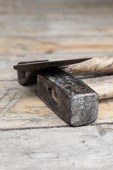 pair of builder work tools ax and heavy hammer on wooden background
