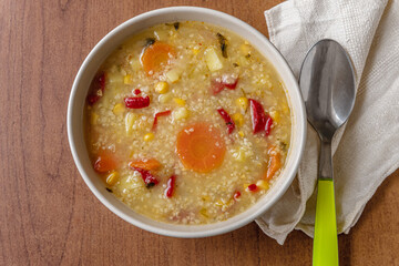 hearty vegetarian vegetable soup with bulgur and corn in a ceramic bowl