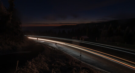 Car light lines on a mountain asphalt road in the evening
