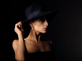 Beautiful makeup woman with elegant healthy neck, nude back and shoulder on black background in fashion hat with empty copy space. Closeup profile view portrait. Art