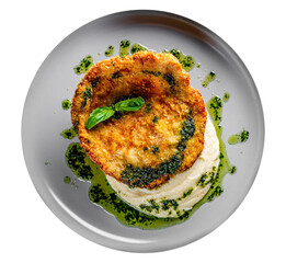 schnitzel with mashed potatoes and pesto sauce on plate isolated on white background