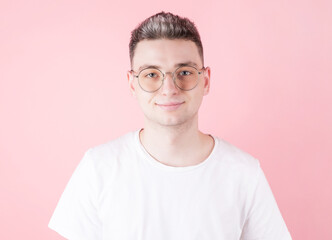 Handsome young caucasian man smiling at camera on pink background
