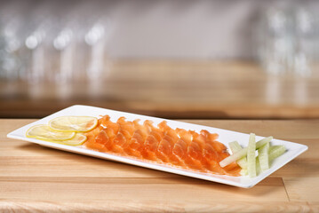 Restaurant menu. Plate with slightly salted and smoked salmon on wooden table background.