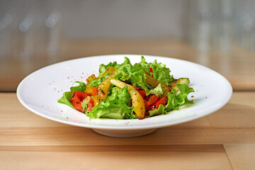 Roasted yellow and red bell pepper salad with capers and olives in a blue bowl.
