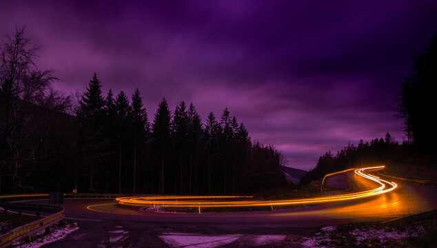 Car light lines on a mountain asphalt road in the evening