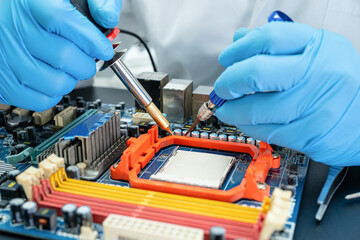 technician repairing inside of hard disk by soldering iron. Integrated Circuit. the concept of...