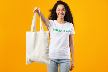 Volunteer Lady Showing White Eco Bag Standing Over Yellow Background