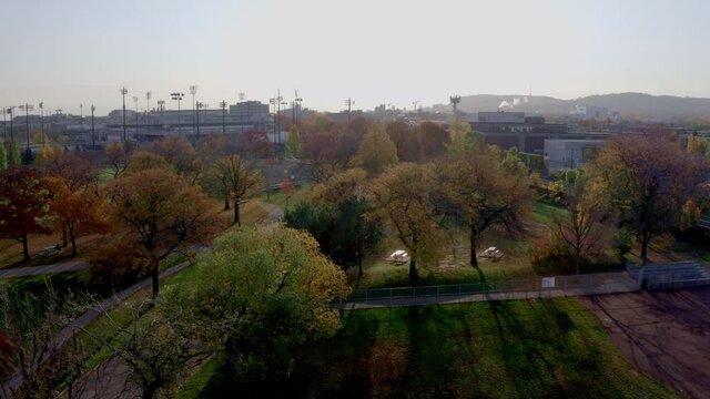 Drone descending over a public parc on a autumn sunny morning