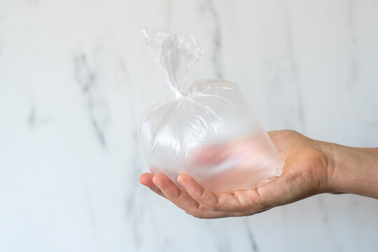 Hand Holding Inflated Plastic Bag. Micro Plastic Pollution Concept