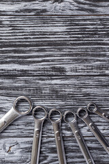 Ring spanners on a black wooden background.