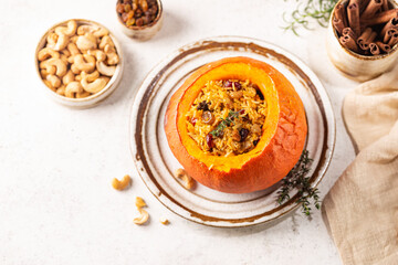 Tasty baked pumpkin stuffed with rice, vegetables, cashews and dried fruits on white background, top view