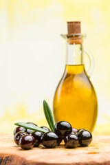 extra virgin olive oil with black olives on olive board