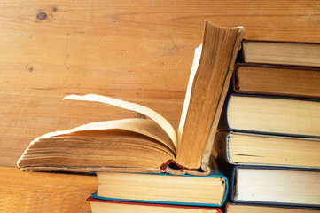 Stack of the books rests upon wooden regiment