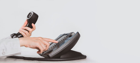 business and communications. Using voip phone in the office, close up of hand with receiver. Conference call, contact us or hotline. IP telephony, Telemarketing. Help desk or call centre. Copy space