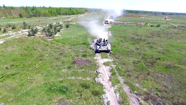 Three military tanks rides on a summer field Aerial shooting