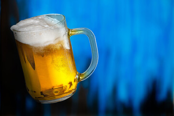 Glass of beer on the blue background