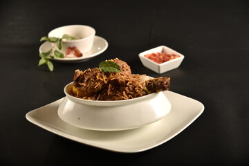 hyderabadi chicken biryani with leg piece garnish with mint leaves