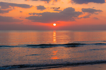 Amazing sunset over the ocean. Beautiful clouds and sun. Bright colors. 