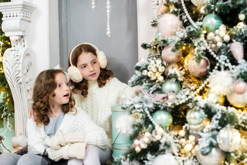 two red-haired sisters on the veranda of a house decorated for Christmas. garland lights, bokeh
