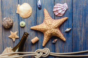 Sea and ocean gifts on a wooden background. Marine things. Sea products. Water Background for real man captains and sailors. Pirate design. Bottle, rope, star. Underwater treasures.