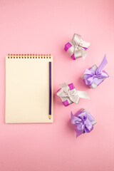 top view little presents with notepad on the pink background photo color new year christmas gift family