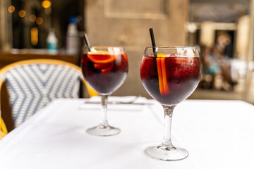 Two red sangria glasses on white tablecloth in restaurant