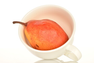 One natural red pear with a white cup, close-up, on a white background.