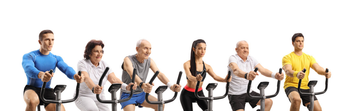 Young and elderly people exercising on stationary bikes