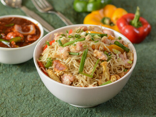 Chicken Noodles a popular indo chinese dish made with chicken, noodles and vegetables, served over a rustic wooden background, selective focus