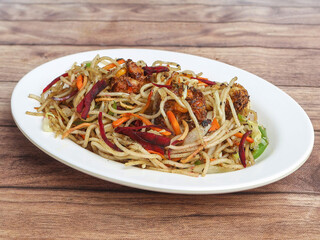 Manchurian Noodles a popular indo-chinese dish served over a rustic wooden background, selective focus