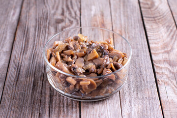 Sliced fried mushrooms in a glass container for further freezing on table