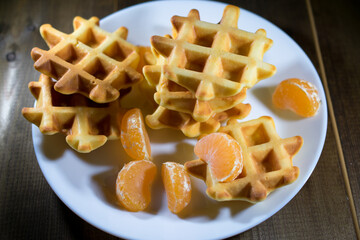 waffles with tangerines on a white plate