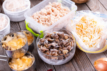 Frozen food. Frozen Casserole. Mushroom, chicken and cheese gratin in bowls on table