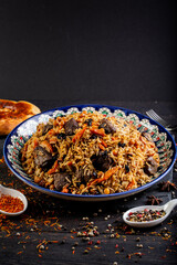 The concept of oriental cuisine. Assorted Uzbek food set, pilaf, samsa, lagman, manta, shurpa central asia food. Homemade Uzbek pilaf or plov from lamb served in cast iron cookware