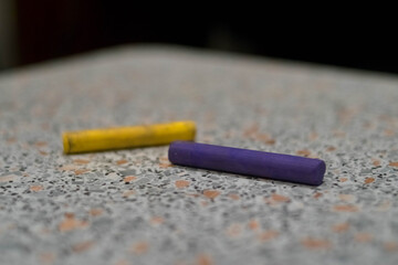 Pastel. Two pieces. Yellow and purple. On a light background. Crayons for drawing. Materials for artists.