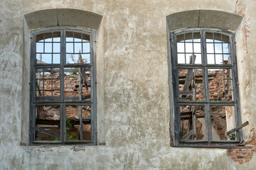 Fototapeta na wymiar Arched Windows with wooden baseline in the wall of an old dilapidated house or Church. Historical value.