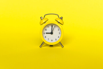 Ringing twin bell vintage classic alarm clock isolated on yellow background. Rest hours time of life good morning night wake up awake concept.