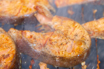 Large fish steaks fresh trout fried in spices on the grill