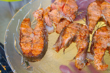Grilled red fish trout steaks lie on a glass plate