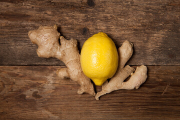 Close up of fresh ginger root spice and lemon on wooden table