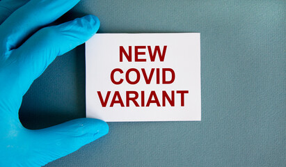 New covid variant symbol. Hand in blue glove with white card. Concept words 'New covid variant'....
