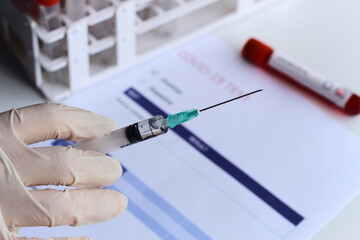 Coronavirus Vaccine vial and syringe with the test results.Vaccine in a bottle with a syringe.