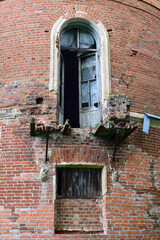 Fototapeta na wymiar Fragment of a building with a door to a collapsed balcony