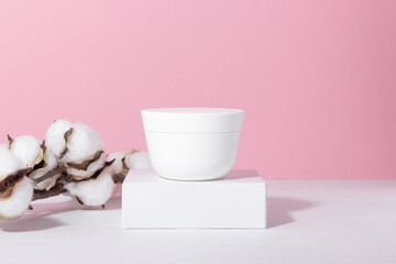 Natural cosmetic. Jar with cream or face mask. White container with women's skin care product on the podium. The concept of a beauty salon and natural cosmetics.