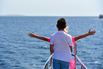 Teen boy hugs teen girl on the bow of a yacht in the sea