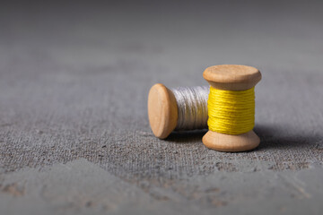 Illuminating Yellow and Ultimate grey colored threads wooden bobbins