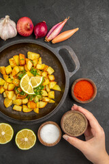 top view tasty fried potatoes inside pan with different seasonings on the dark background cuisine meal food calorie pepper